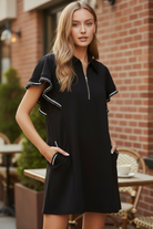 Umgee LUXEKNIT black mini dress upper body close-up showing half-zip collar neckline and double layer butterfly ruffle sleeves with white and black contrast crochet trim
