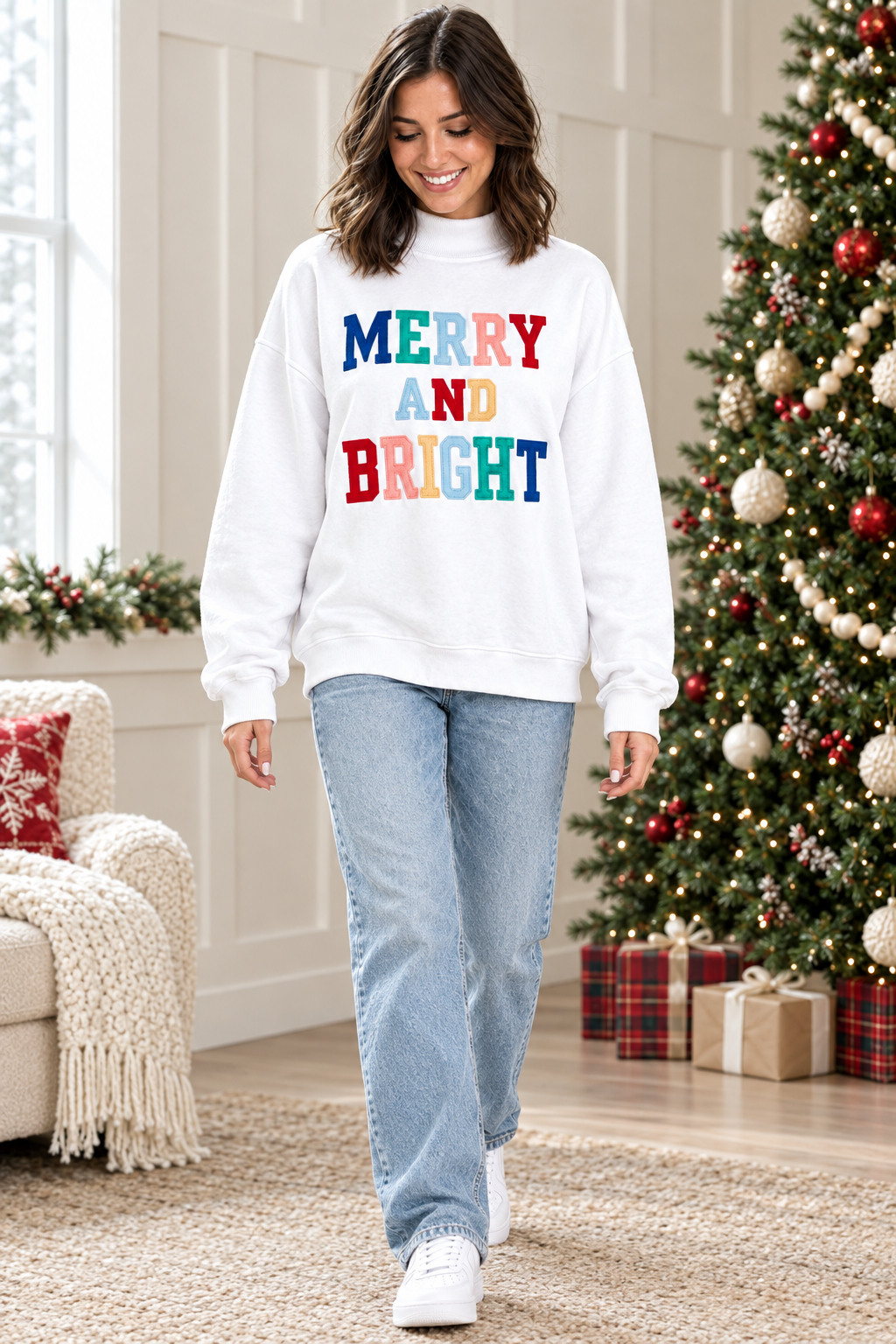 Full-length view of white Merry and Bright holiday pullover paired with light wash jeans and white sneakers