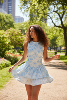 Light blue floral athletic romper dress with ruffles in outdoor natural setting