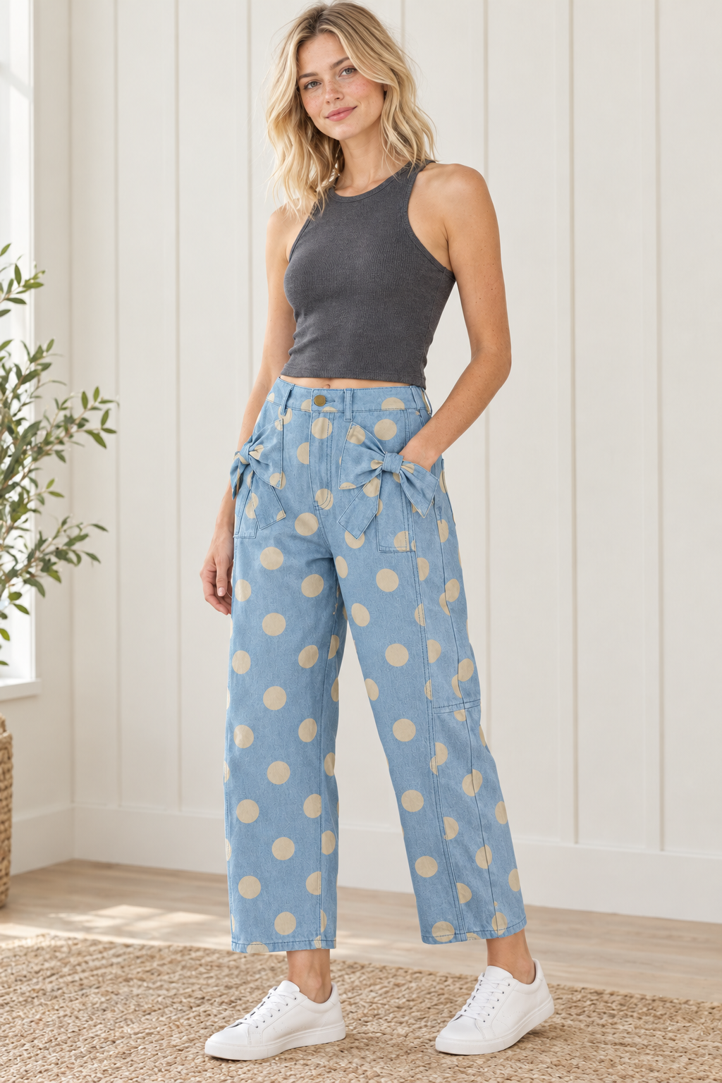 Angled view of sky blue polka dot jeans with front pocket bows, side panel seams and relaxed cropped legs