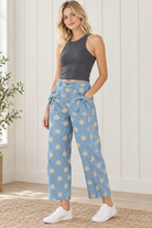 Angled view of sky blue polka dot jeans with front pocket bows, side panel seams and relaxed cropped legs