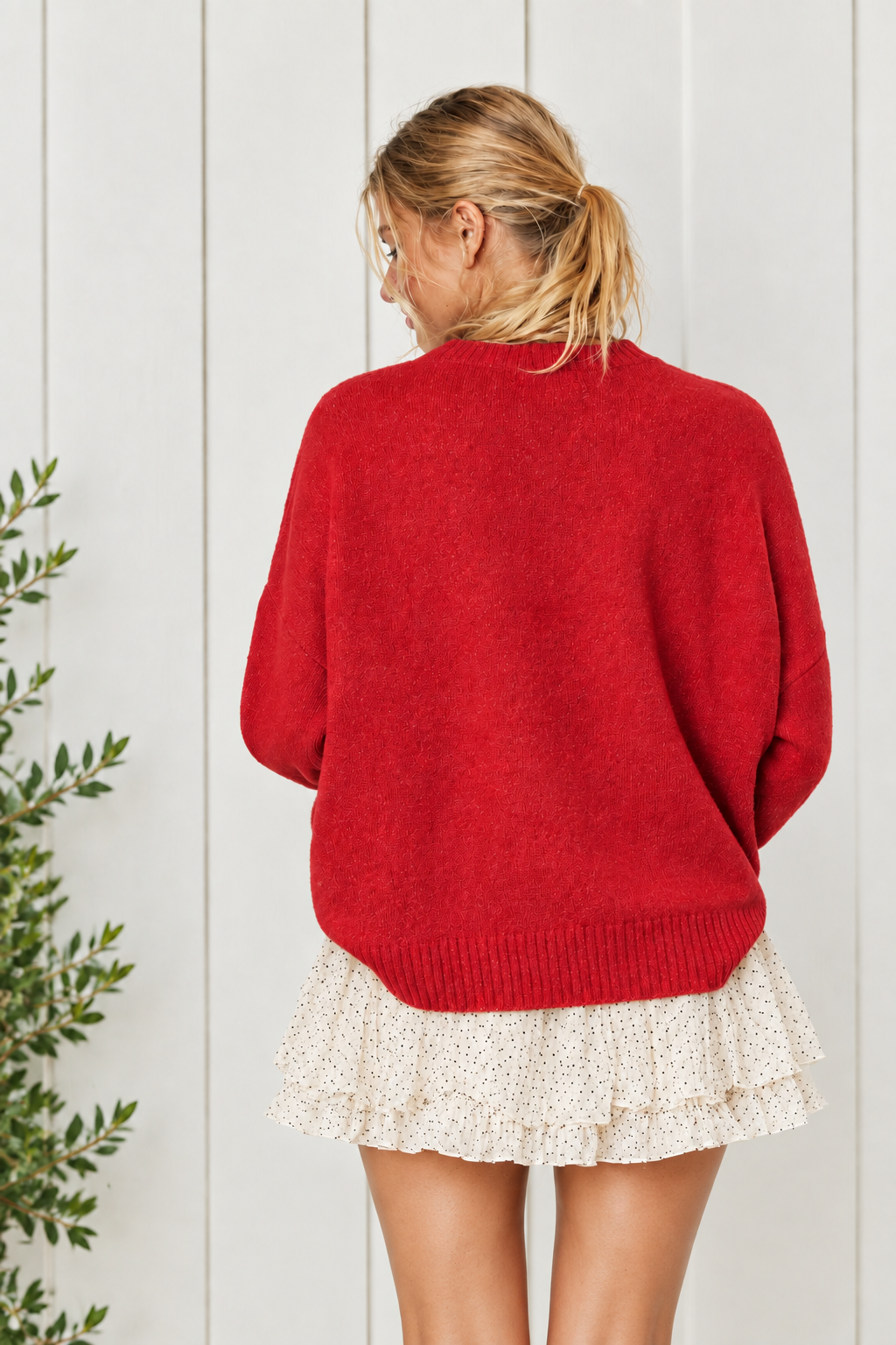 Back view of red Holly Jolly sweater showing plain knit back, dropped shoulders and ribbed hem