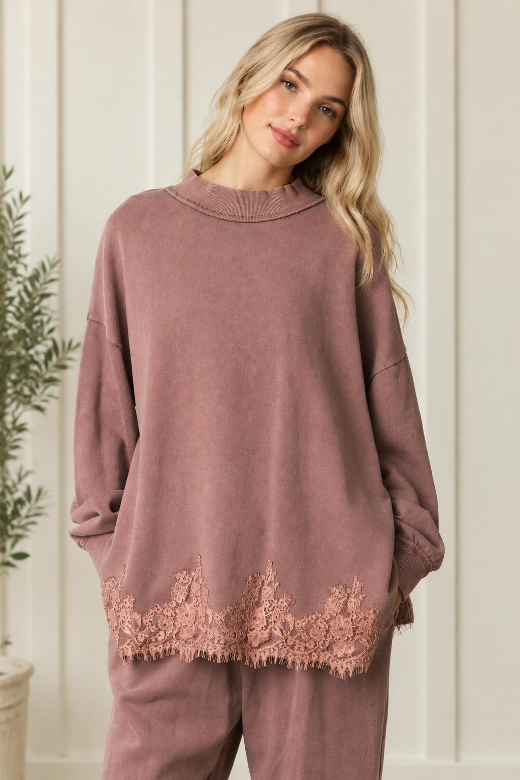 Front styling detail of mauve-brown French terry track pants paired with the coordinating floral lace hem sweatshirt.