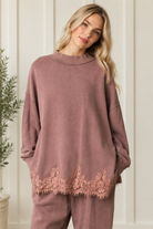 Front styling detail of mauve-brown French terry track pants paired with the coordinating floral lace hem sweatshirt.