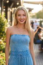 Acid wash strapless tube top jumpsuit waist-up close-up — smocked waistband and drawstring tie detail deep sky blue blonde model