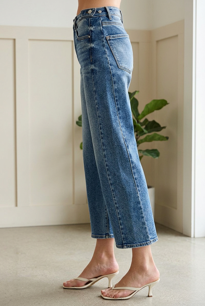 Side view of RISEN high rise cropped barrel jeans highlighting the adjustable waistband and curved leg silhouette.
