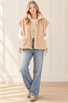 Beige boxy sherpa vest styled with an ivory top, light wash jeans and sneakers