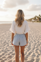 Classic stripe high waist denim shorts back view showing single back pocket, full body beach lifestyle photo
