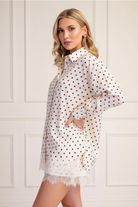 Ivory polka dot lace trim oversized shirt three-quarter side angle, hand on hip pose, worn as matching set with polka dot shorts