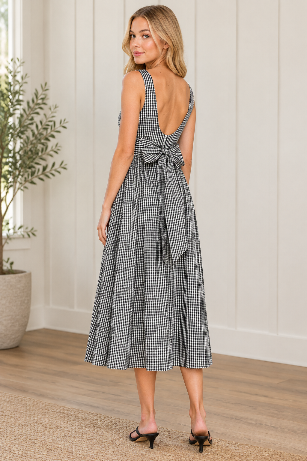Back view of black and white gingham midi dress showing open scoop back and waist level self tie bow
