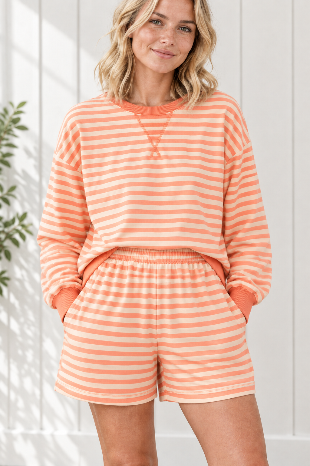 Close-up of orange and cream striped outfit with crew neckline, stitched V detail, ribbed trim and elastic-waist shorts