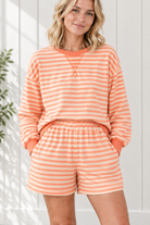 Close-up of orange and cream striped outfit with crew neckline, stitched V detail, ribbed trim and elastic-waist shorts