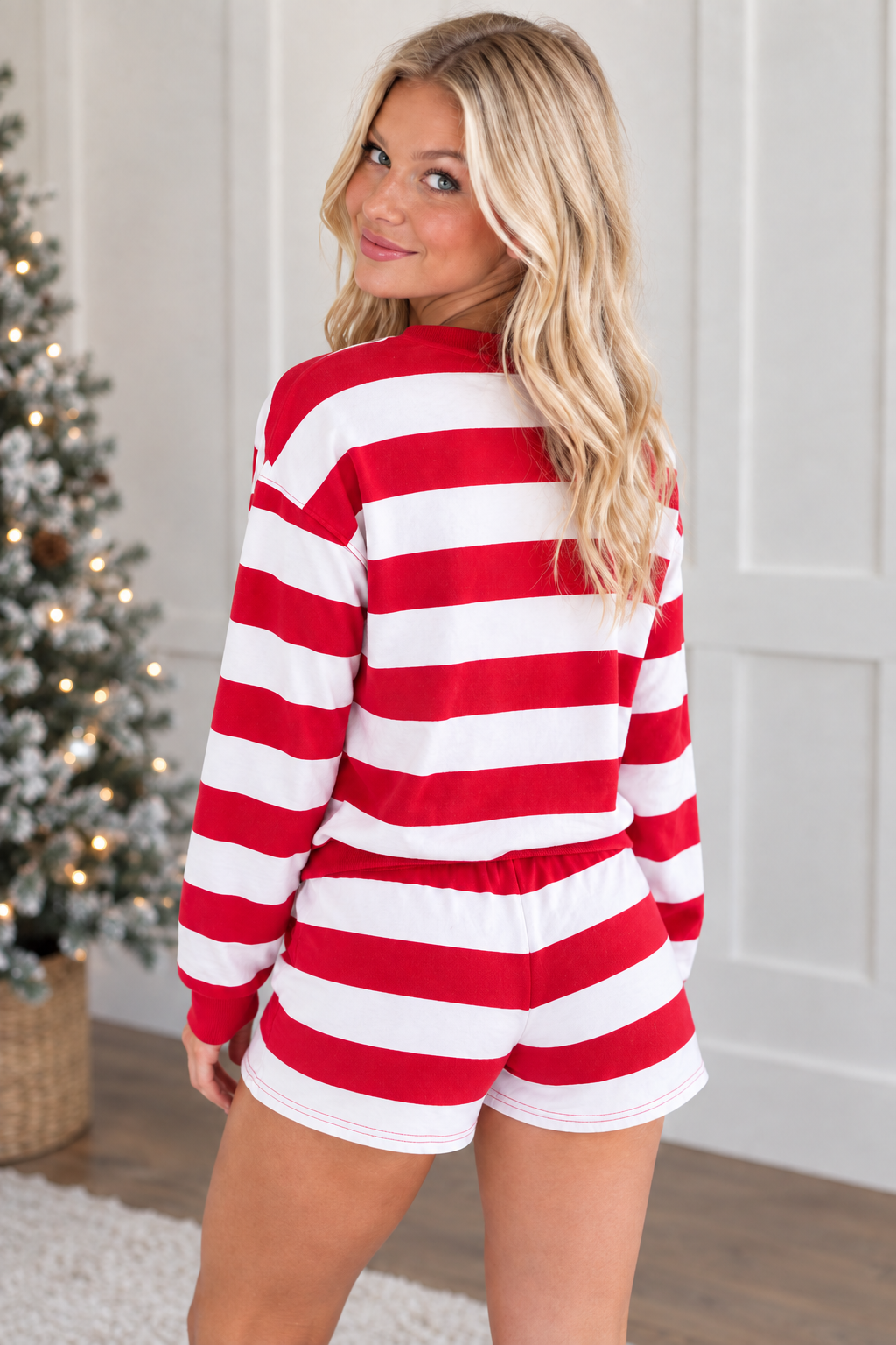 Rear view of red and white striped long sleeve pullover and matching holiday shorts with plain striped back