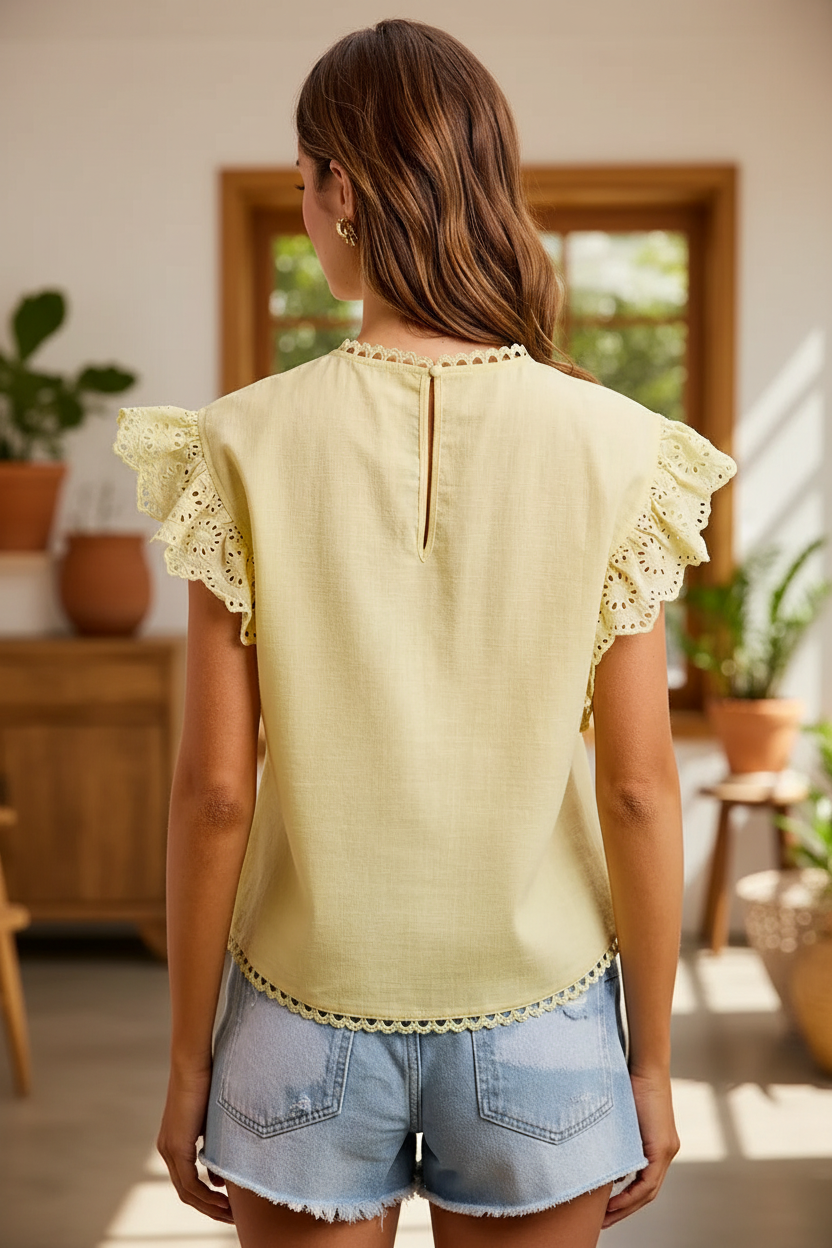 Back view of BiBi creamy yellow cotton ruffle eyelet blouse showing keyhole back closure and double-layer ruffle eyelet sleeves, styled with light wash denim shorts, shop Thread Bar Boutique
