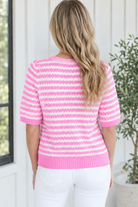 Back view of pink and white striped short sleeve knit sweater with pink ribbed hem