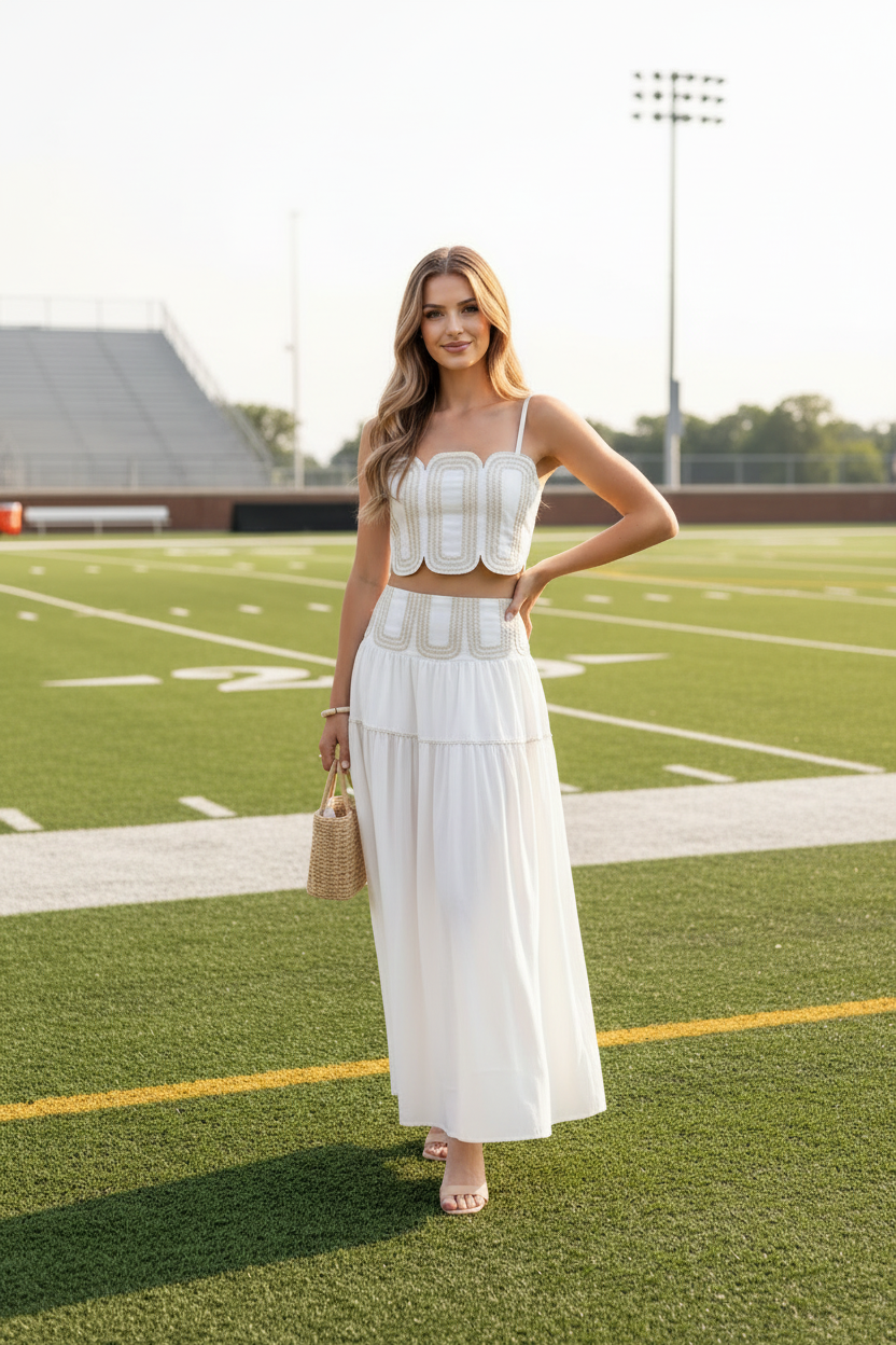 Blonde model wearing white lace arch crop top and tiered maxi skirt set - front facing on football field with yard lines