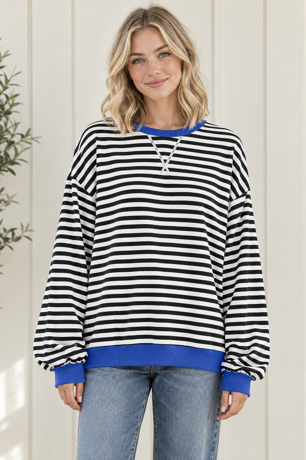 Front view of women's oversized black and white striped sweatshirt with blue trim and drop shoulders.