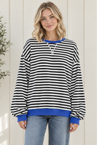 Front view of women's oversized black and white striped sweatshirt with blue trim and drop shoulders.