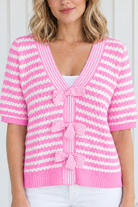 Close-up of pink and white textured knit stripes, V-neck trim and three striped front bows