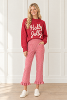 Front view of red gingham pants showing a large patch pocket, high waist, straight leg cut and ruffle trimmed ankle hems.