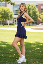 Navy active mini dress side cutout detail — open waist cutout, fitted bodice, pleated skirt hem, athletic dress with built-in shorts