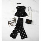 Black and white polka dot matching set flat lay with peplum top, barrel pants, heels, purse, and accessories
