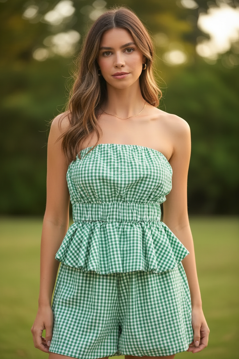 Close-up detail of kelly green gingham seersucker strapless smocked tube top showing gathered ruffle peplum at waist and double-layer ruffle hem detail