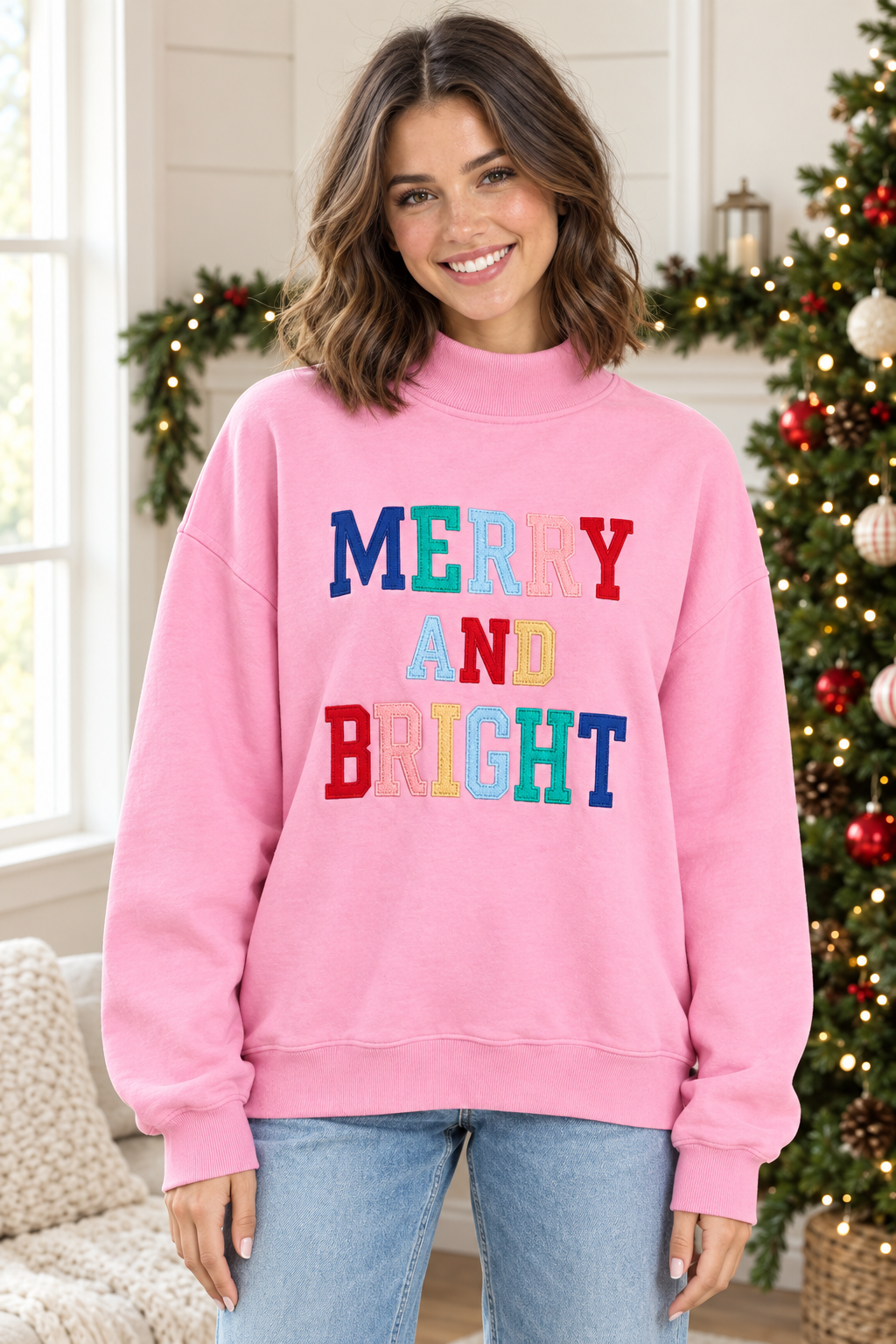 Pink Merry and Bright mock neck pullover, front view with multicolor stitched lettering and ribbed hem