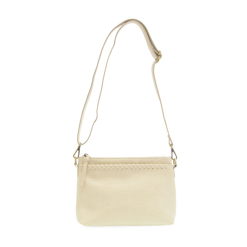 Sleek buffalo grain vegan leather pouch clutch with removable straps for a day-to-night western look. cross body view cream