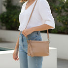 Sleek buffalo grain vegan leather pouch clutch with removable straps for a day-to-night western look. shoulder strap view