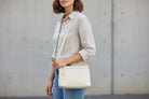 Sleek buffalo grain vegan leather pouch clutch with removable straps for a day-to-night western look. shoulder strap view