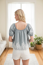 Lace denim top back view in front of window