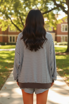 Dark brunette model wearing brown stripe oversized long sleeve top and matching drawstring shorts - back view showing full matching set outdoors