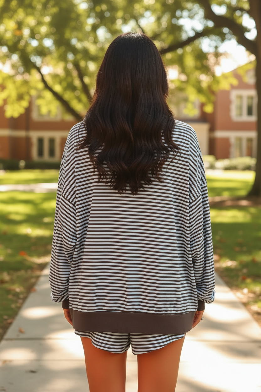 Dark brunette model wearing brown stripe oversized long sleeve top and matching drawstring shorts - back view showing full matching set outdoors