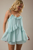 Mint green ruffle romper with soft woven fabric and tie straps from Thread Bar Boutique, a feminine boutique romper perfect for spring and summer outfits.