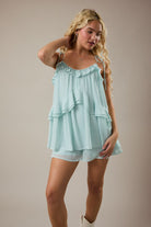 Mint ruffle romper with adjustable shoulder ties and flowy flared shorts from Thread Bar Boutique, a feminine summer romper perfect for warm-weather outfits.