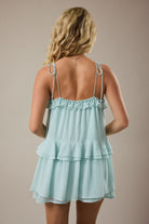 Lightweight mint ruffle romper with flared shorts and tie shoulder straps from Thread Bar Boutique, a trendy women's boutique summer romper. rear view