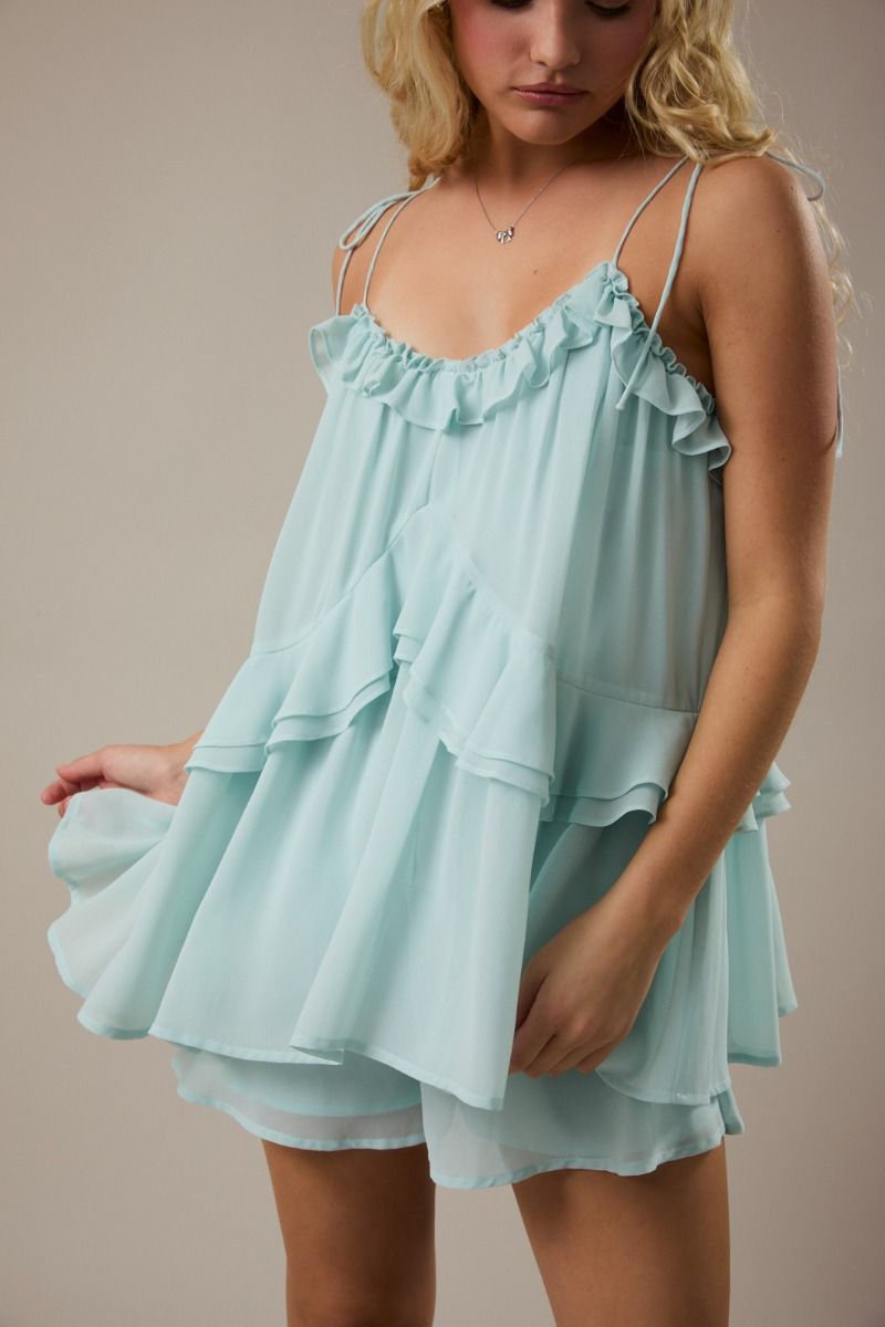 Women's mint green ruffle romper with tie shoulders and breezy flared legs from Thread Bar Boutique, a stylish lightweight summer boutique romper.