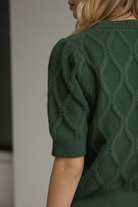 Lightweight pine green sweater with cable knit detailing, short puff sleeves, ribbed neckline, cuffs, and hem from Thread Bar Boutique
