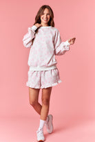 Soft white sweatshirt with pink floral print for women from Thread Bar Boutique

White thigh-length drawstring shorts with pink floral print for women from Thread Bar Boutique