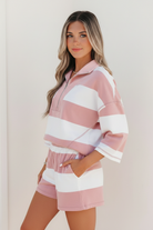 Pink striped two-piece set with metal half-zip placket, bracelet-length sleeves, and coordinating stripe print