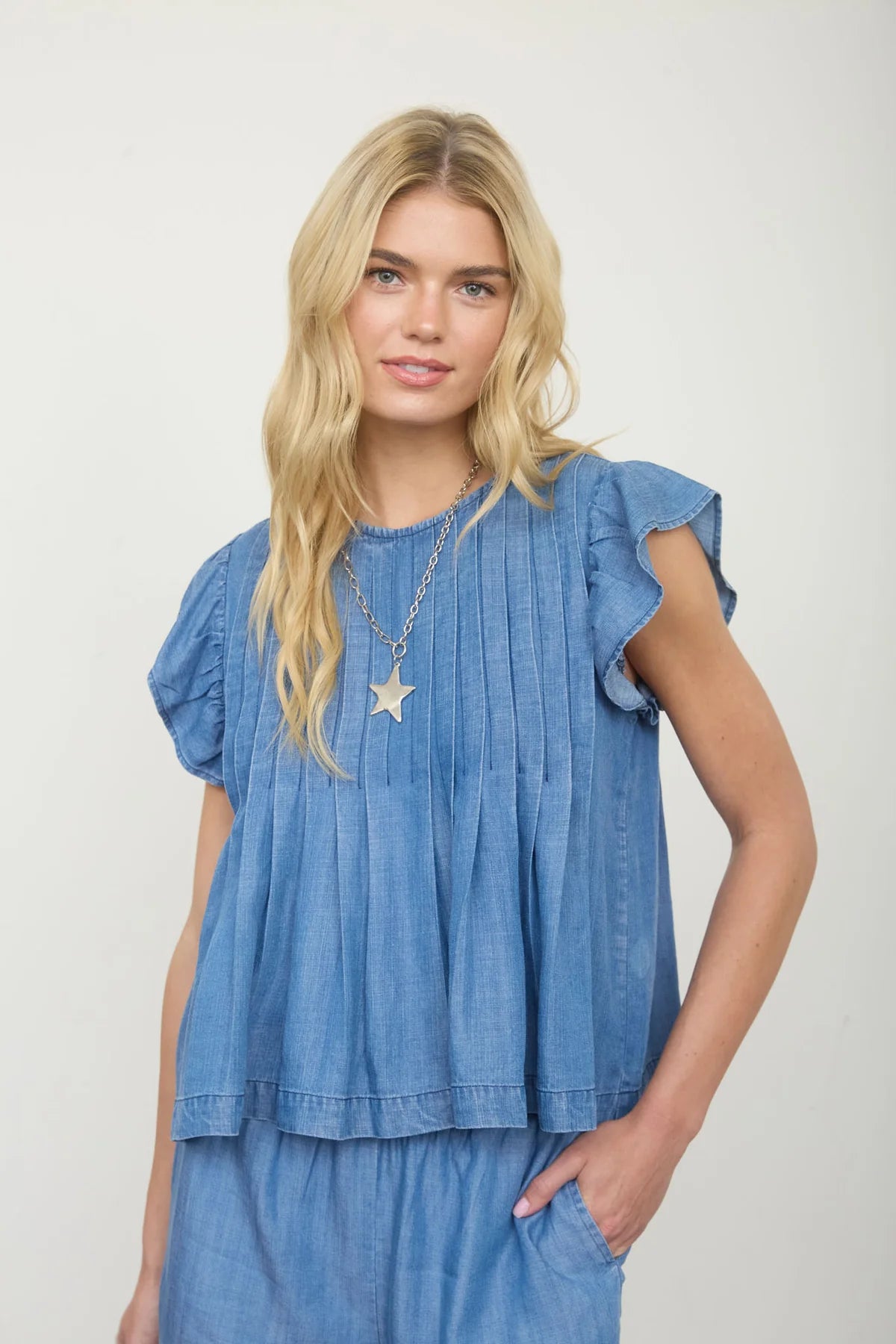 Blue pintuck denim top with ruffle sleeves and front pintuck detaiL