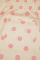 Close-up of pink polka dot fabric on a beige background