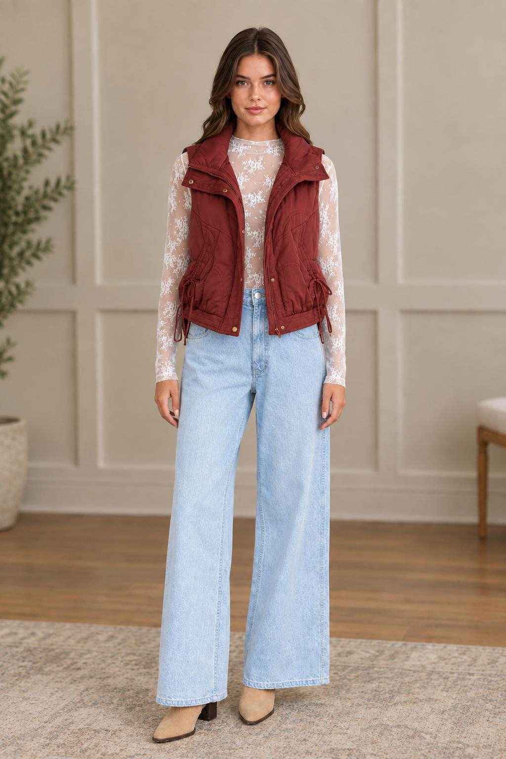Maroon wave quilted puffer vest worn open with stand collar, gold snap buttons, and drawstring hem ties from Thread Bar Boutique