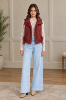 Maroon wave quilted puffer vest worn open with stand collar, gold snap buttons, and drawstring hem ties from Thread Bar Boutique