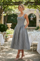 Elegant black gingham dress with square neck and voluminous pleated skirt