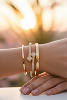 Stainless steel bangle bracelet featuring double clover design with sparkling cubic zirconia stones