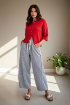 Striped drawstring barrel pants full body front view — flattering high-waist barrel silhouette with elasticized waistband and cropped red cardigan styling