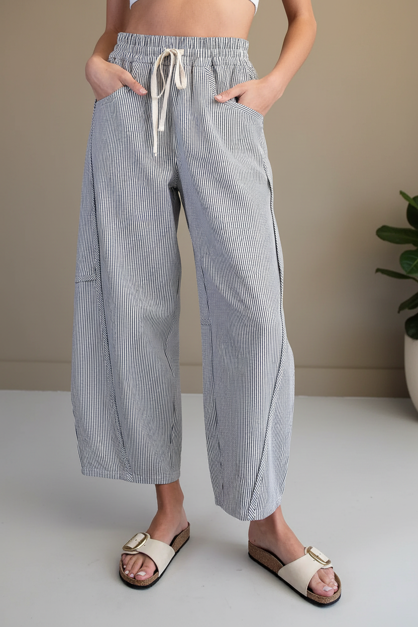 Striped drawstring barrel pants front waist-down detail — deep side pockets, cream drawstring tie, navy pinstripe cotton fabric