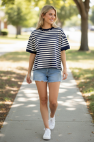 navy ivory oversized stripe short sleeve top with denim cutoff shorts and white sneakers on sunny sidewalk